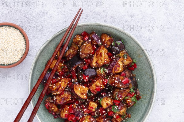 Fried eggplant, Chinese style, in sweet and sour sauce, with pepper and sesame seeds, in a green