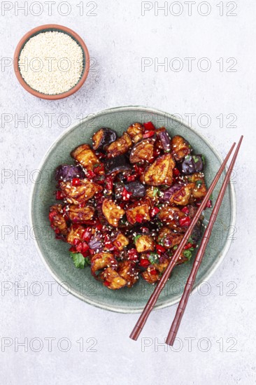 Fried eggplant, Chinese style, in sweet and sour sauce, with pepper and sesame seeds, in a green