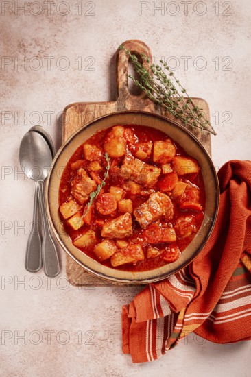 Meat goulash with potatoes and carrots, sweet peppers, in a saucepan, top view, traditional