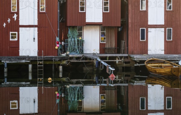 Boats and falun red boathouses in the harbour of Smögen, Smögenbryggan, Västra Götalands Län,
