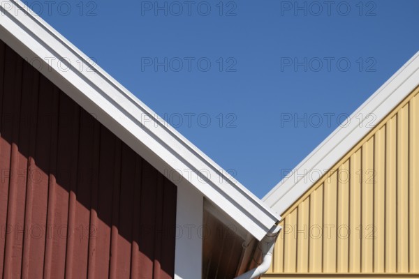 Red and yellow house gables bordering each other, blue sky, Fjällbacka, Bohuslän, West Sweden,