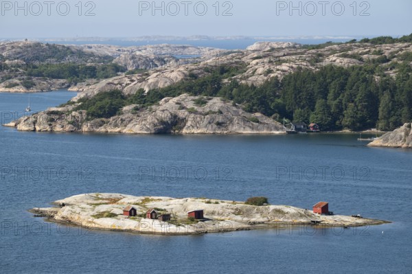 Archipelago landscape with rocks and an offshore archipelago island with falun red woodsheds,