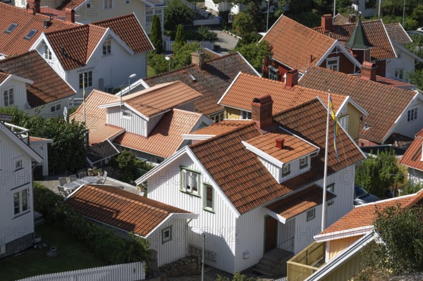 Bird's eye view of traditional, white Scandinavian wooden houses with orange-red roofs, Fjällbacka,
