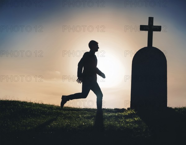 A silhouette of a lone figure walking off a gravestone, The scene evokes Resurrection thoughts