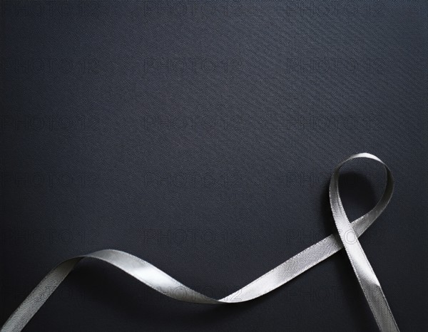 A beautifully wrapped gift box adorned with colorful satin ribbons forming a bow, contrasting