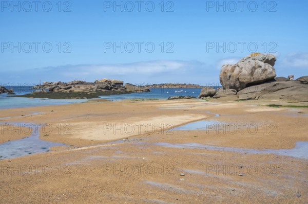 Spectacular pink granite rocks, sculpted by wind and sea, pile up on the beach of the Cote de