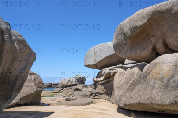 Spectacular pink granite rocks, sculpted by wind and sea, pile up on the beach of the Cote de