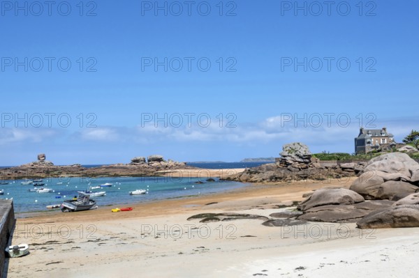 On the harbour beach of Tregastel on the Cote de Granit Rose, small sailing boats lie on the light