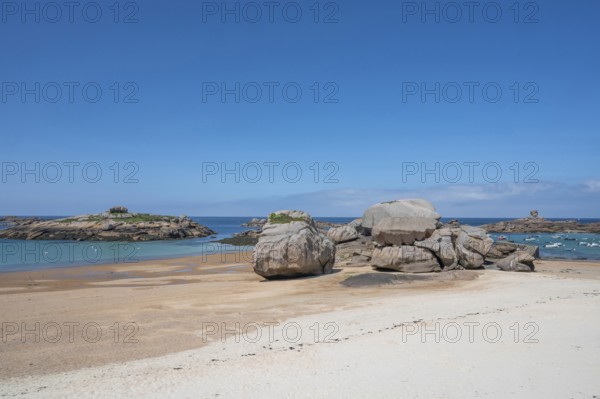 Spectacular pink granite rocks, sculpted by wind and sea, pile up on the beach of the Cote de