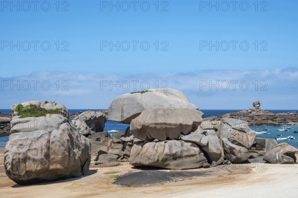 Spectacular pink granite rocks, sculpted by wind and sea, pile up on the beach of the Cote de