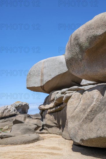 Spectacular pink granite rocks, sculpted by wind and sea, pile up on the beach of the Cote de
