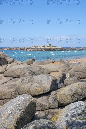 The wide bay of Tregastel on the Cote de Granit Rose shows the turquoise blue sea with white