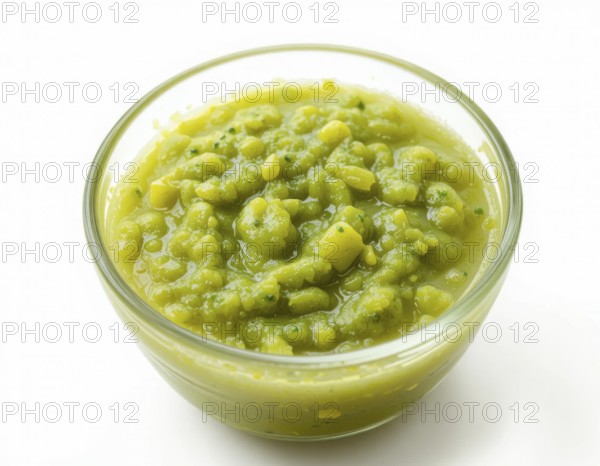 A clear glass bowl holds a thick, textured pea soup, showcasing a fresh, healthy meal. The bright