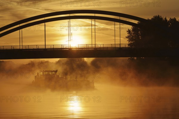 Ship on the Datteln-Hamm Canal in the morning fog at sunrise, Bergkamen, North Rhine-Westphalia,