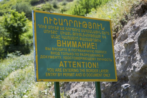 A multilingual warning sign regulating access to the border zone, sign in front of a military post