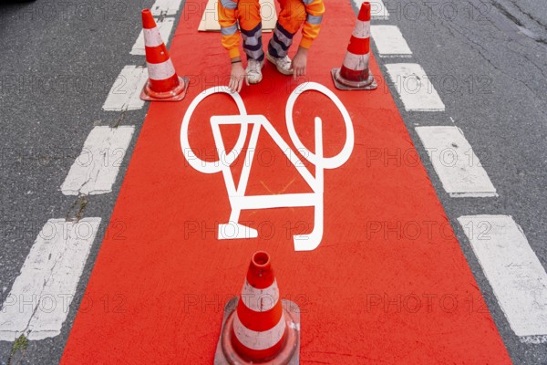 Application of red road surfacing on a cycle lane, inner-city road, so-called cold plastic