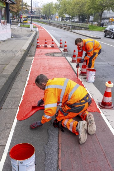 Application of red road surfacing on a cycle lane, inner-city road, so-called cold plastic