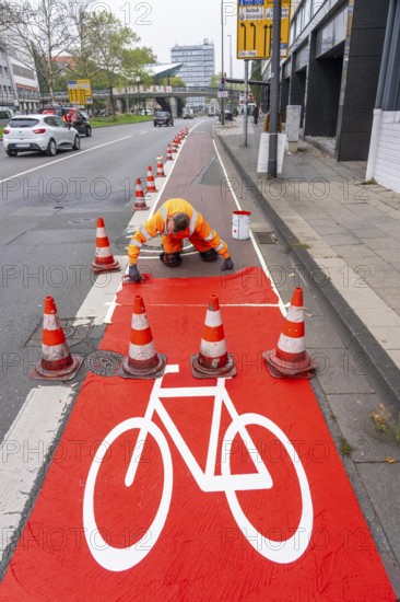 Application of red road surfacing on a cycle lane, inner-city road, so-called cold plastic