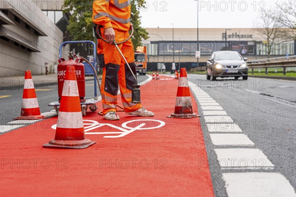 Application of red road surfacing on a cycle lane, inner-city road, so-called cold plastic