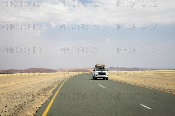 Inside Sossusvlei, gravel roads wind and a car through red dunes to Deadvlei, Big Daddy, and