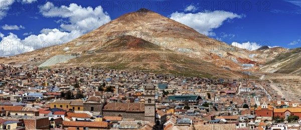 Expansive view of a city in front of an impressive mountain and blue sky, The silver mountain Cerro