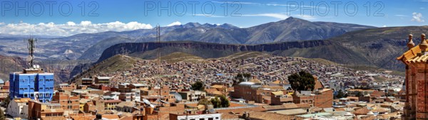 Far-reaching panorama with cityscape and surrounding mountains under a clear sky, view over the
