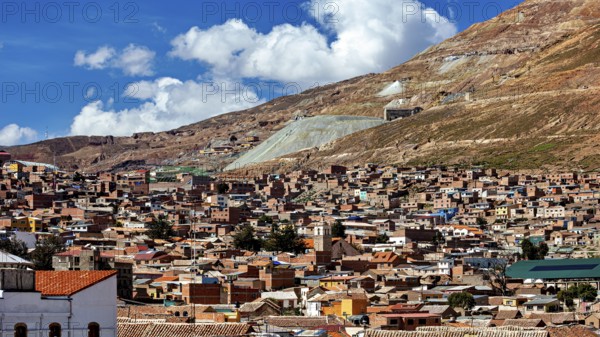 City view with many brick houses at the foot of the hills under a blue sky, The silver mountain