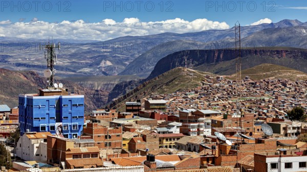 Urban landscape with red tiled roof architecture and a telecommunications tower in front of a