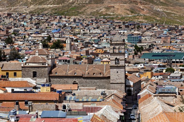 Aerial view of a densely built-up city with colonial towers and colourful roofs in a mountainous