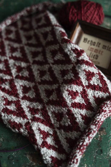 Knitted piece with ball of wool and framed picture with the lettering Behalt ich immer lieb