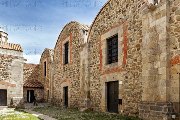 Historic stone buildings with tile accents and curved roofs under a blue sky, The historical museum