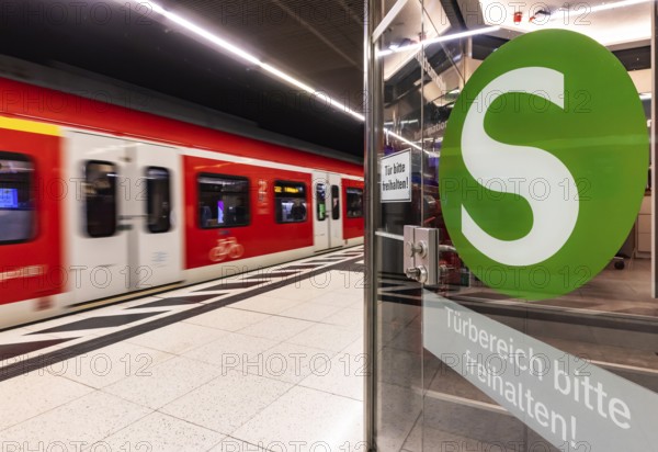 S-Bahn arriving underground at the main station stop. Platform with travellers and logo. Stuttgart,
