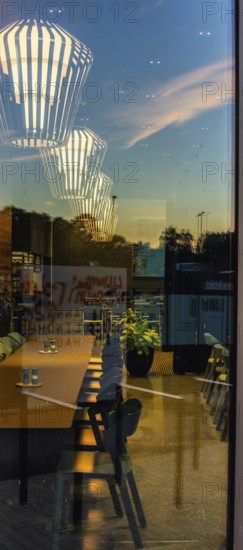 The picture shows the interior of a modern Berlin pub, taken in the evening. The scene is