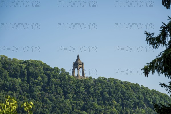 A monument rises on a wooded hill under a clear blue sky, Kaiser Wilhelm Monument,