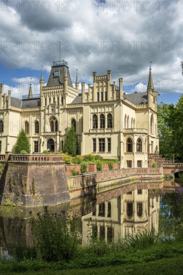 The Gothic castle with moat is picturesquely reflected in the water, Evenburg Castle, Leer, East