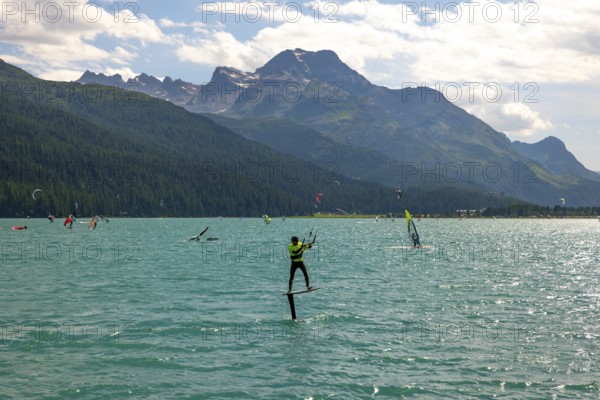 Kitesurfing on Alpine Lake Silvaplana in a Sunny Summer Day with Mountain View in the Swiss Alps in