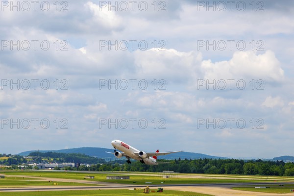 Swiss Airlines Passenger Airplane Take Off From the Runway and Flying Against Blue Sky and Clouds