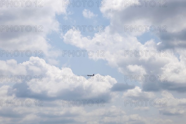 Passenger Airplane Flying Against Blue Sky and Clouds in a Sunny Summer Day From the Airport in