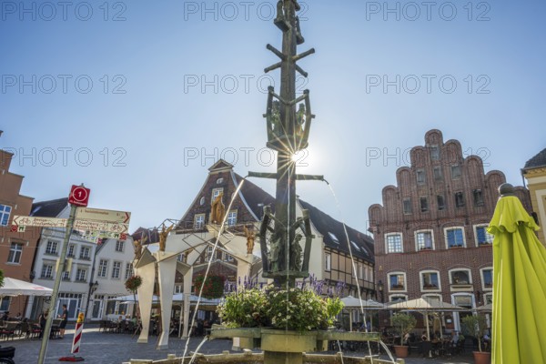 A fountain with fountains in a central square surrounded by half-timbered houses, Warendorf,