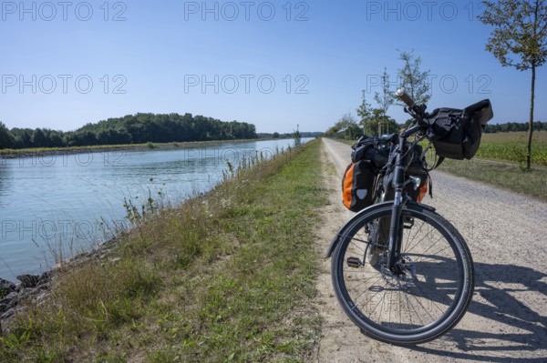 Bicycle on the riverside path under a clear sky. Sunny day with a view of the countryside,