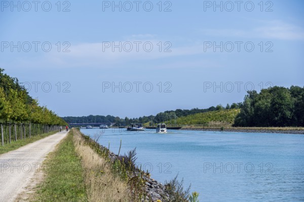 Canal with boats and clear sky. Calm water surrounded by nature and a gravel path, Dortmund-Ems