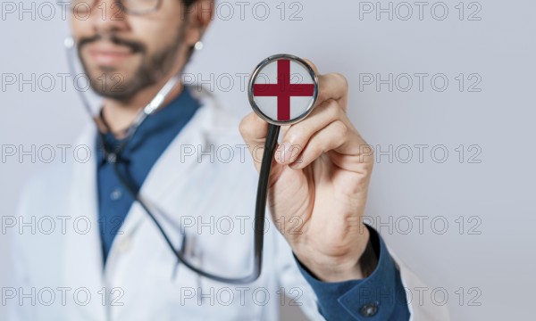 Doctor holding stethoscope with England flag. England health and care concept. England flag on