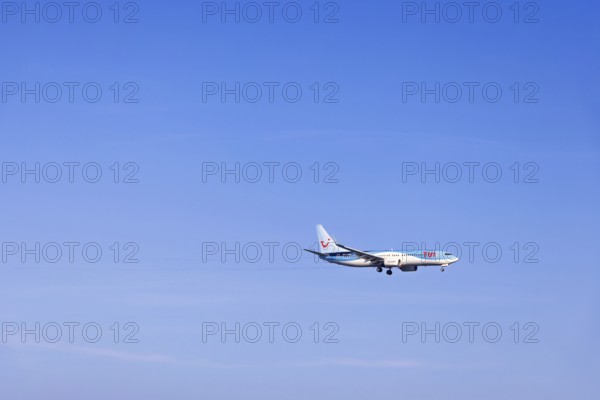 Passenger plane with tourists from the travel company Tui flying on a clear blue sky, Mallorca,