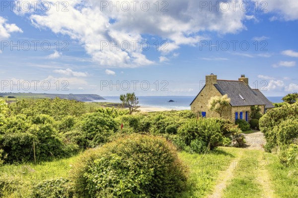 Idyllic old stone house with a seascape view at the sea horizon in a coastal landscape a sunny