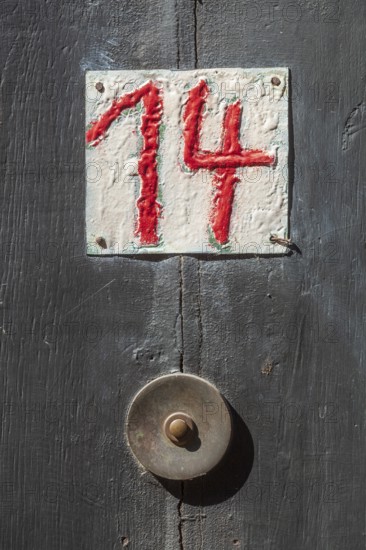 House number sign number fourteen and old doorbell on a half-timbered house in the old town centre,