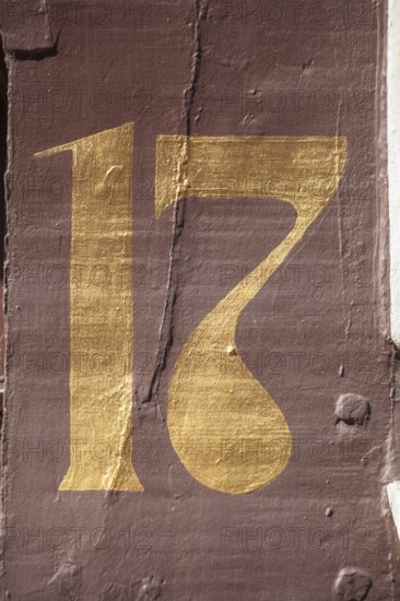 Golden house number plate number seventeen on a half-timbered house in the old town centre,