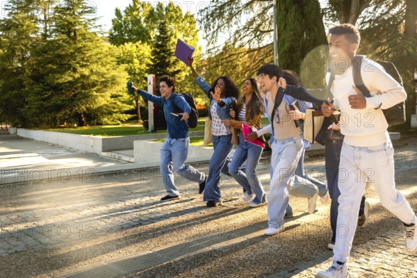 Group of excited multiracial students. Wearing casual clothes and carrying backpacks and books.