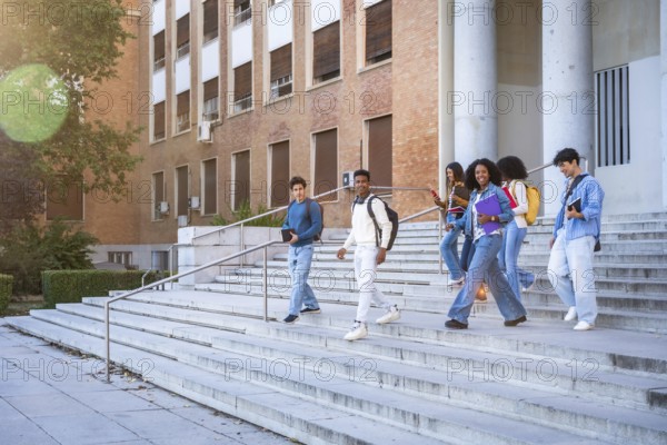 Diverse group of young students smiling, talking, and walking down the outdoors stairs of a