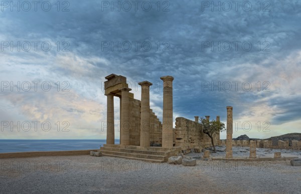 Ancient ruins of the Temple of Athena on the Acropolis of Lindos with columns in front of a calm