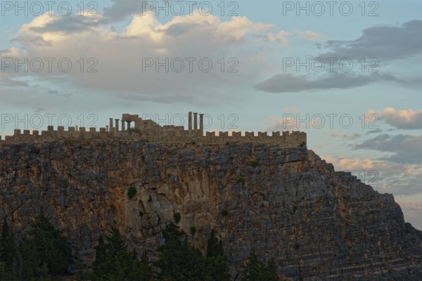 The ancient Acropolis of Lindos on jagged rocks against a dramatic sky at dusk, Acropolis, Lindos,